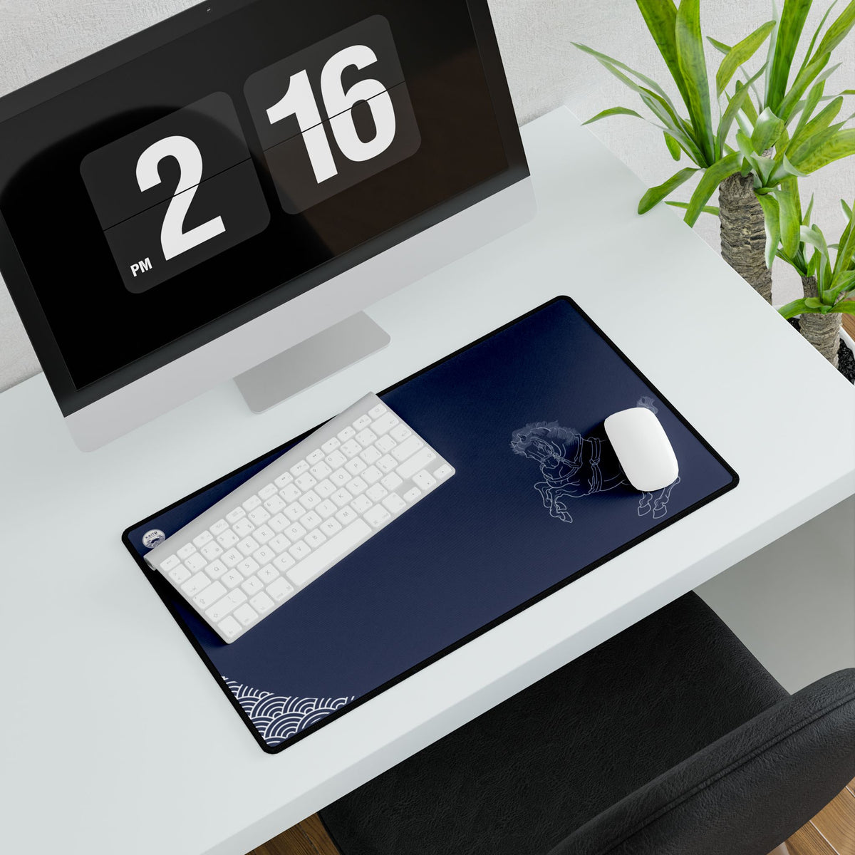 Desk setup with a computer, keyboard, mouse, and desk pad on a white desk.