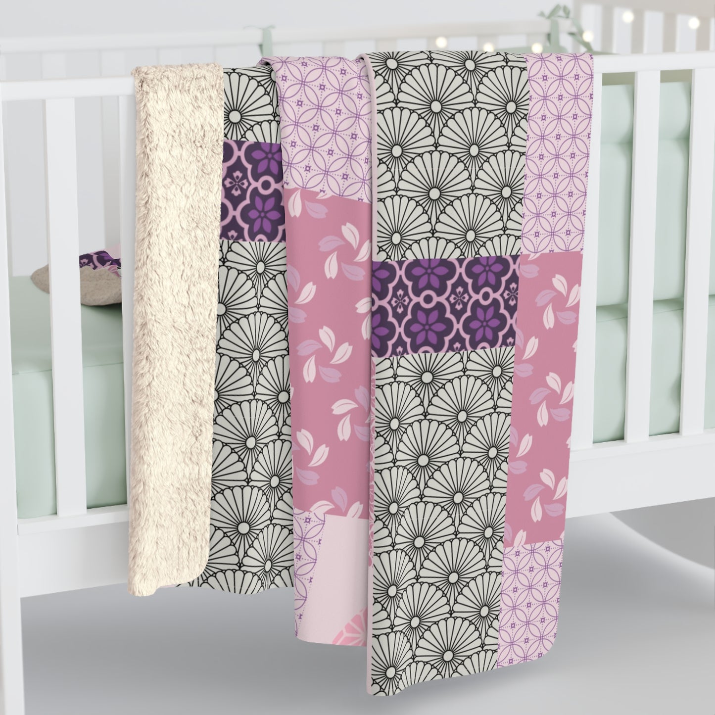 Patterned quilt draped over a crib with a white background