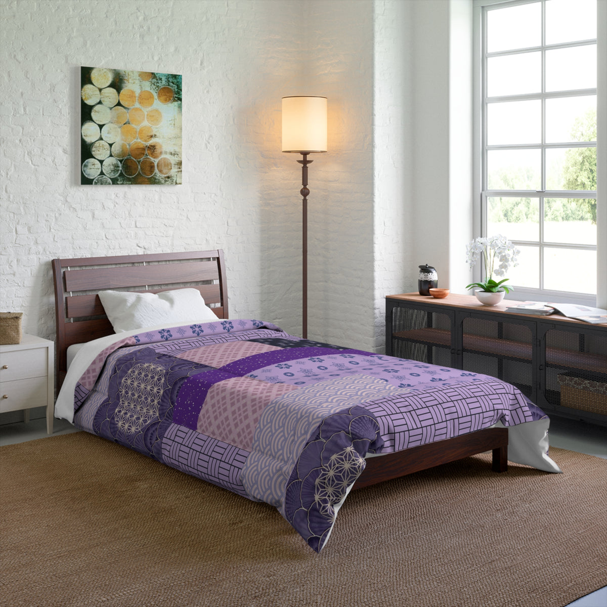 Bedroom with a bed covered in a purple quilt, lamp, and artwork on the wall.