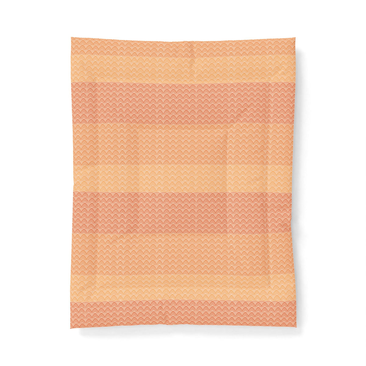 Woven blanket with a geometric pattern in shades of orange and pink on a white background. Heritage Cotton