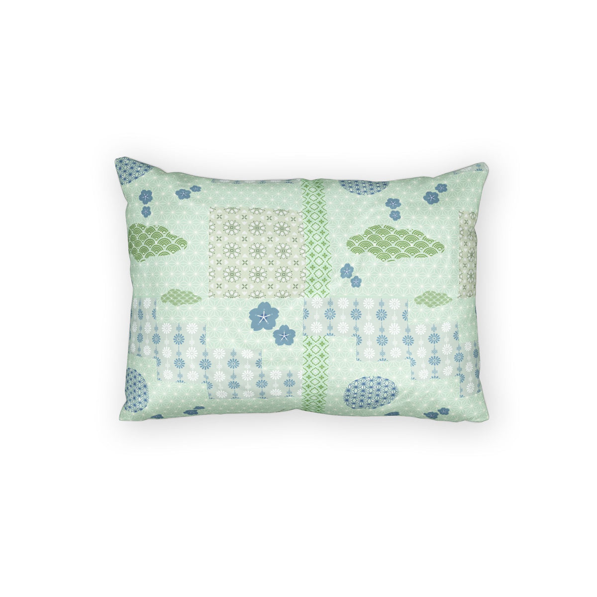 A rectangular decorative throw pillow featuring a patchwork-style print with light green, sage green, and blue patterns, including geometric grids, floral motifs, and dotted lines, set against a plain white background.