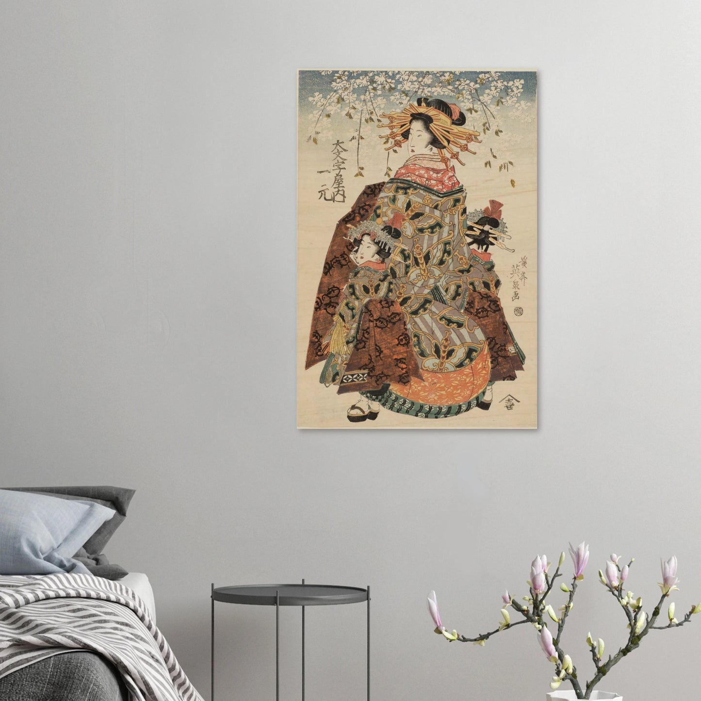 Traditional Japanese artwork of a woman in a kimono on a gray wall above a bed.