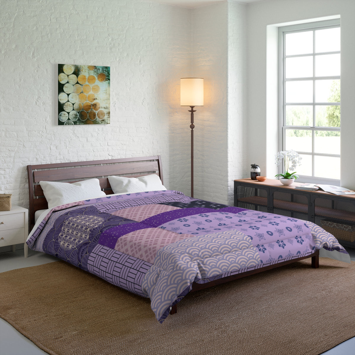 Bedroom with a bed covered in a purple patchwork comforter, a lamp, and a painting on the wall.