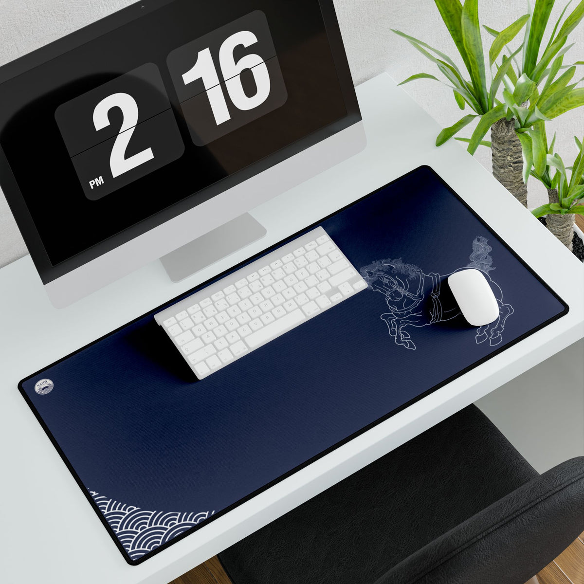 Desk setup with a computer, keyboard, mouse, and large desk mat featuring a design.