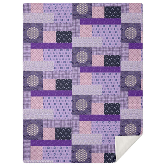 A high-angle, square photograph of a minimalist professional study featuring a dark walnut wood lounge chair. Neatly draped over the chair is the Purple Geisha Blanket from Kaito Japan Design. The blanket showcases a deep, royal purple palette with a striking patchwork of traditional Wagara patterns and elegant Geisha-inspired motifs. Natural morning light creates a calm and sophisticated atmosphere