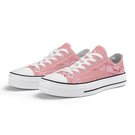 Classic low-top canvas sneakers featuring a soft pastel pink background with a delicate white and rose-pink cherry blossom (Sakura) pattern.
