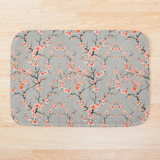 Embrace the vibrant energy of a Japanese spring with the Peach Sakura Bath Mat. This eye-catching bathmat features a cheerful pattern of stylized blossoms reminiscent of delicate cherry blossoms (sakura), rendered in shades of white against a soft grey background