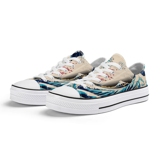 A pair of low-top canvas sneakers, predominantly light beige, featuring a vibrant Japanese-inspired design. The print depicts a dynamic blue and white "Great Wave" pattern at the base, with a serene landscape above, including rolling hills and delicate pink cherry blossoms against a light sky. The sneakers have white laces, white rubber toe caps, and white rubber soles with a black stripe. They are presented at an angle on a plain white background.