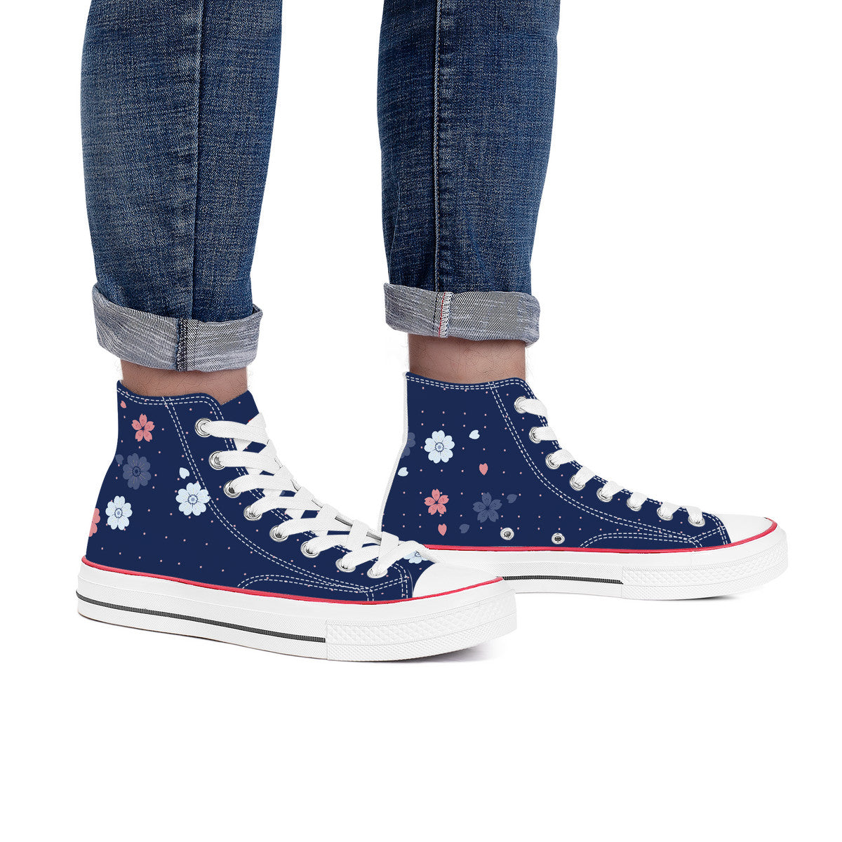 Navy high-top sneakers with floral patterns worn with rolled-up jeans on a white background