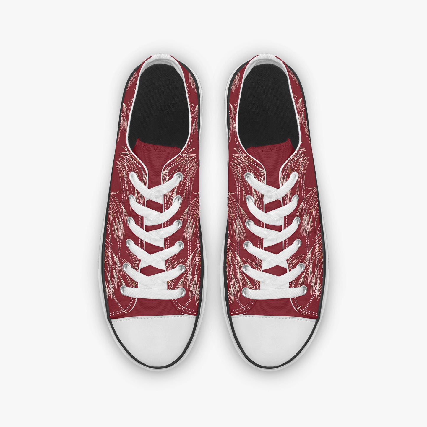 A pair of low-top canvas sneakers shown from a top-down view. The uppers are a deep red with a white sketch-style line art pattern, featuring white laces and white rubber toe caps.