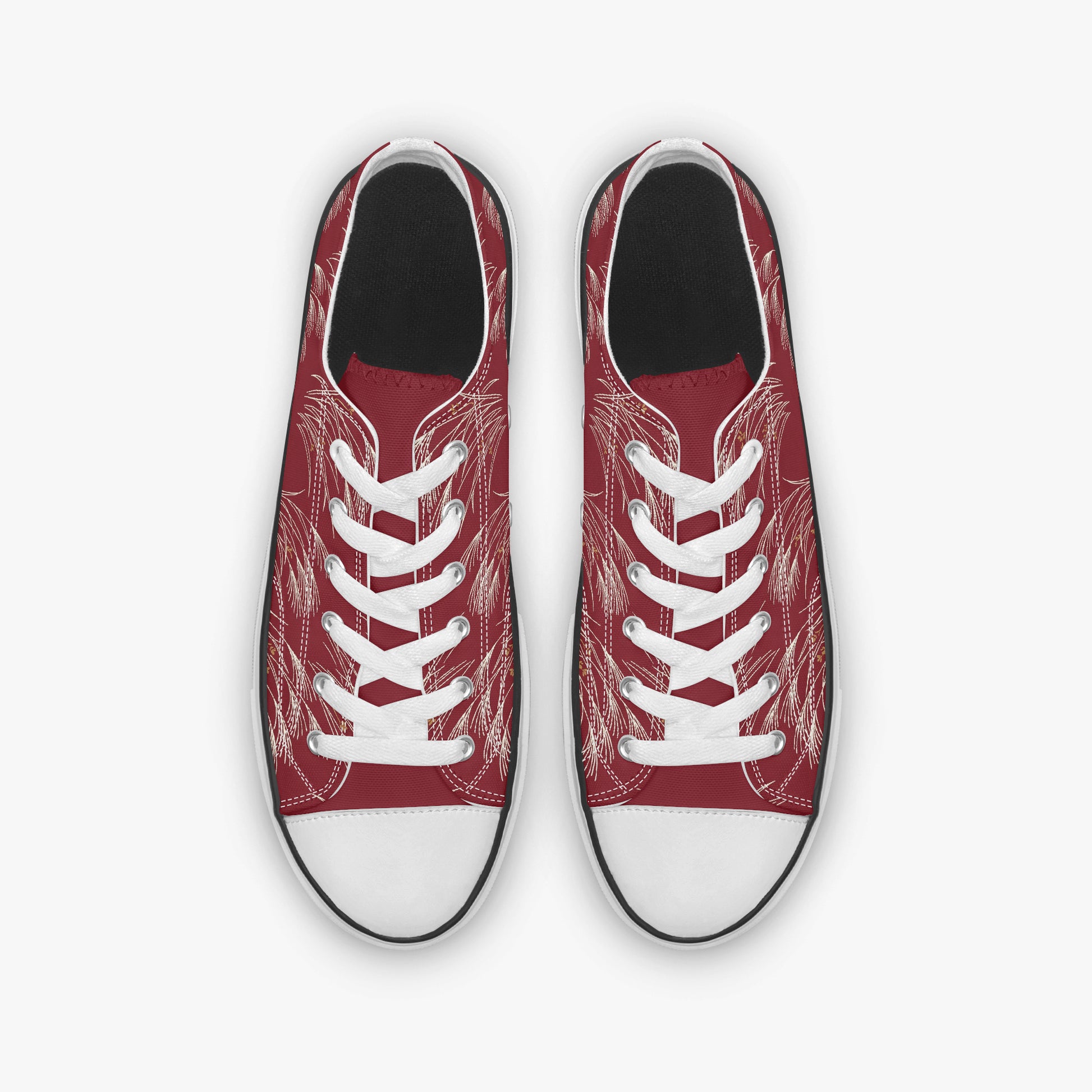 A pair of low-top canvas sneakers shown from a top-down view. The uppers are a deep red with a white sketch-style line art pattern, featuring white laces and white rubber toe caps.
