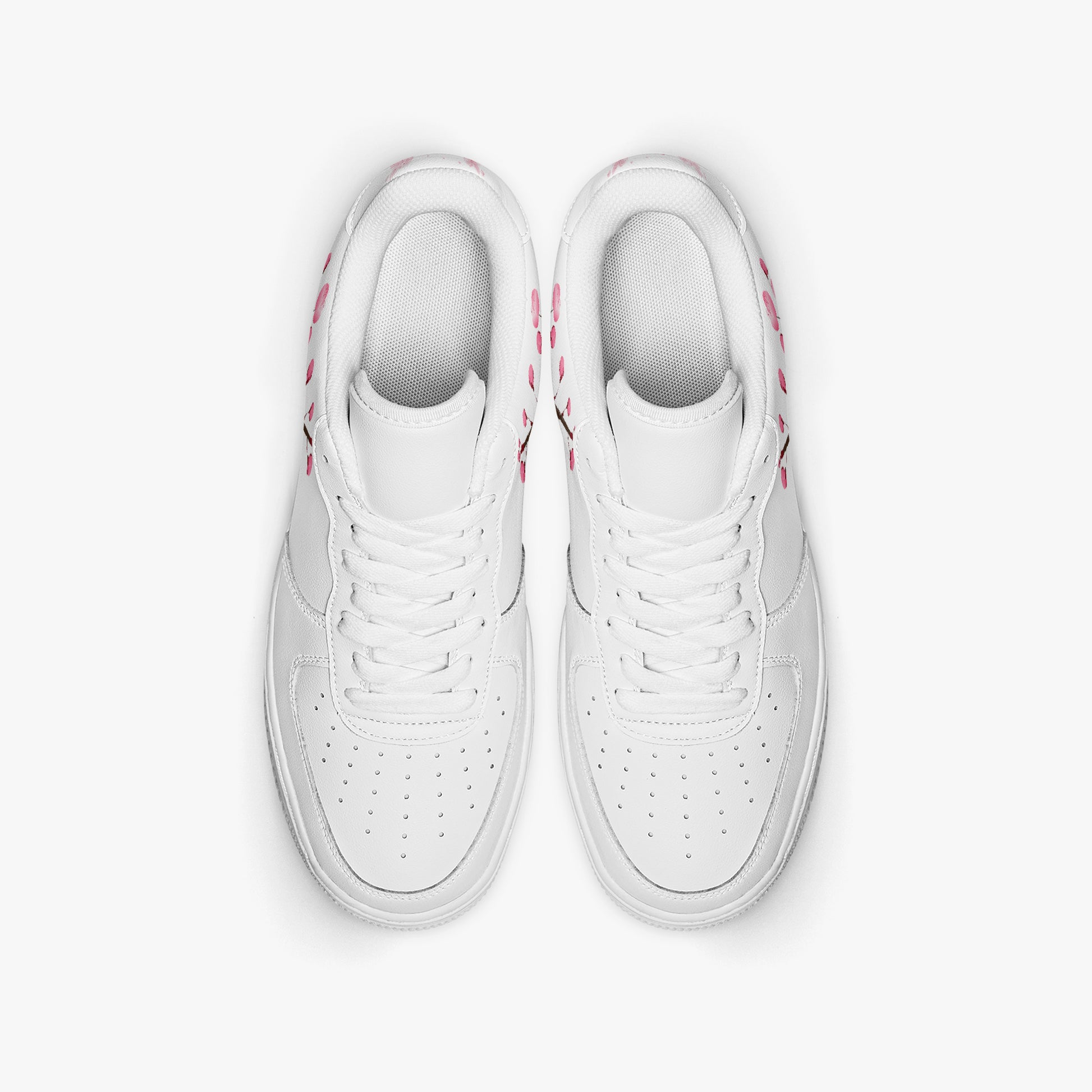 Pair of white sneakers with pink accents on a light gray background