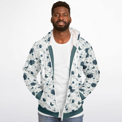 A man wearing a white zip-up hoodie with a blue floral pattern, teal green trim, and a white t-shirt underneath, photographed against a solid white background.