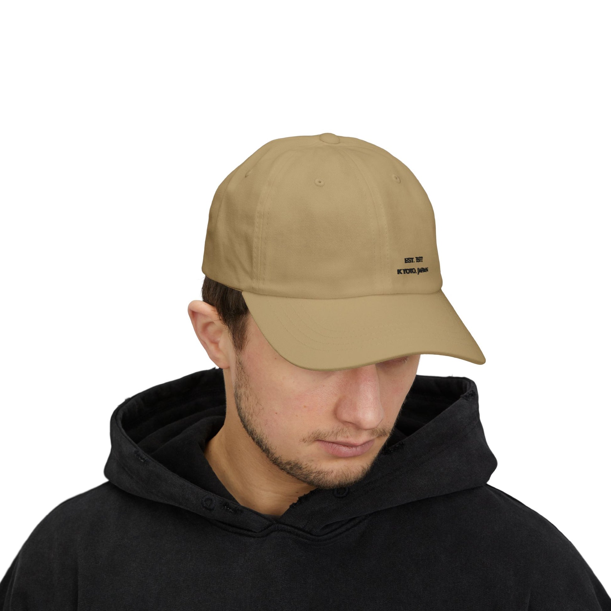 Man wearing a beige cap with a logo on a white background