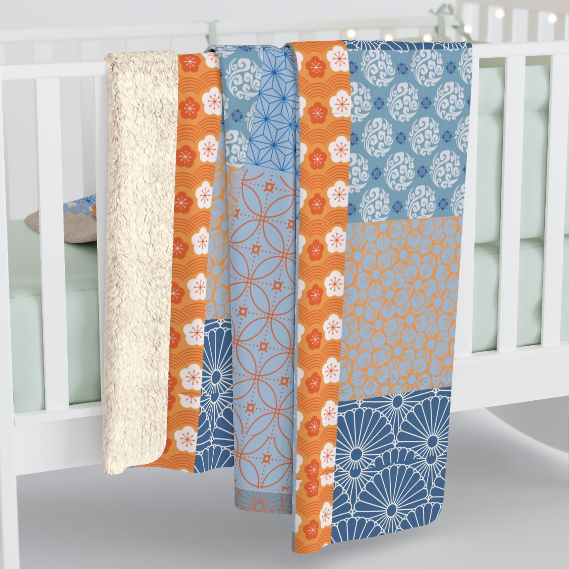 Patterned crib sheet with blue and orange design on a white crib