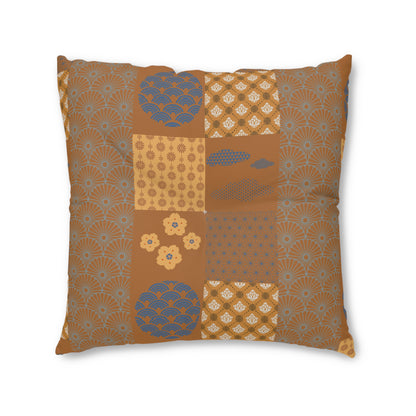 A square decorative throw pillow featuring a patchwork design of various Japanese-inspired patterns in brown, beige, and blue-gray, shown against a plain white background.