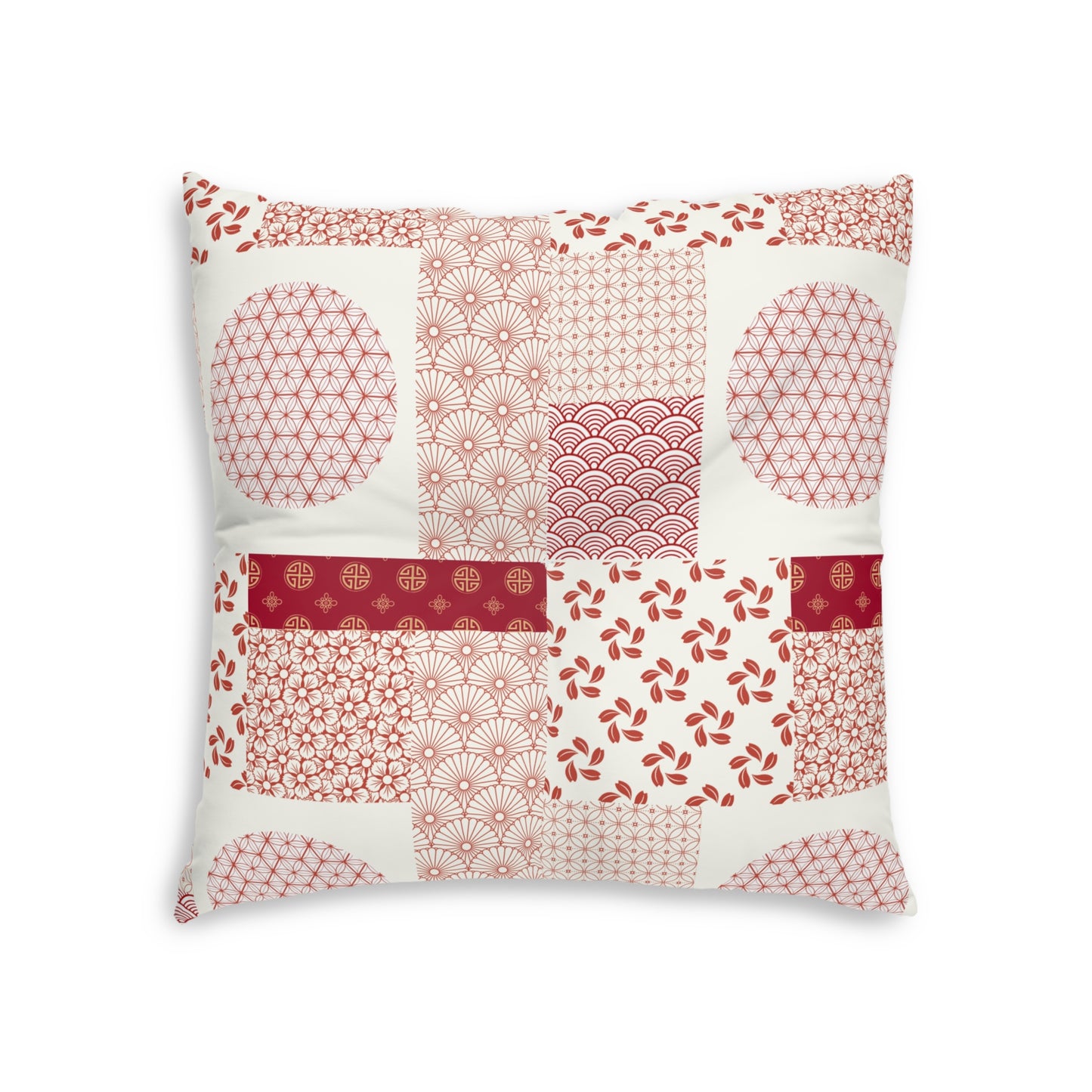A square decorative throw pillow featuring a patchwork design of red and pink Japanese-inspired patterns on an off-white background, set against a plain white studio backdrop.