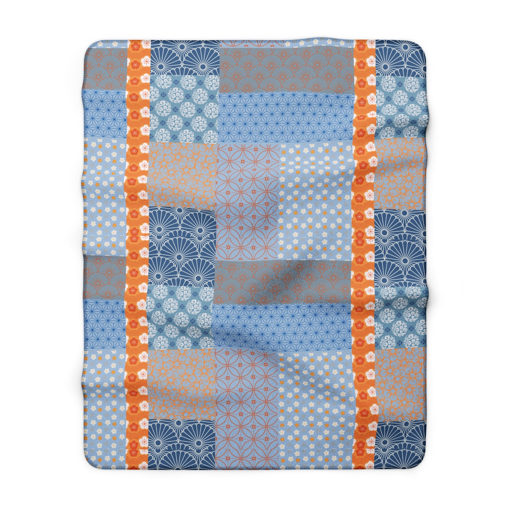 Patchwork blanket with blue, orange, and gray patterns on a white background