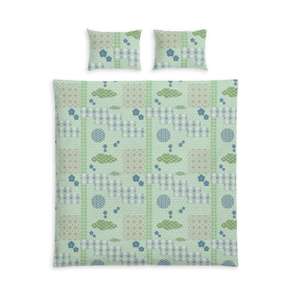 A bedding set featuring a duvet cover and two matching pillowcases with a patchwork-style geometric pattern in sage green, light blue, and beige on a white background.