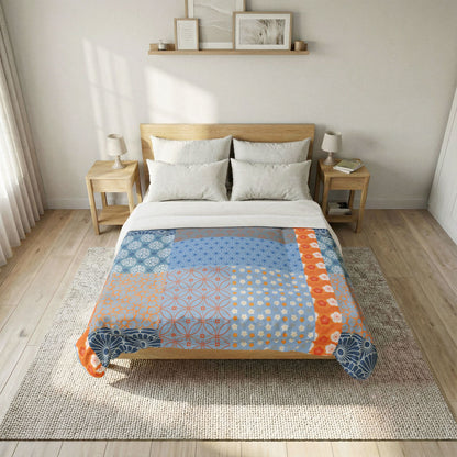 Bed with a colorful quilt in a bedroom setting. Heritage Cotton