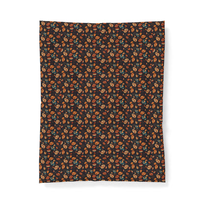 A rectangular fabric item, likely a blanket or towel, featuring a dense all-over floral pattern in orange, teal, and cream on a dark brown background, shown flat against a white backdrop.