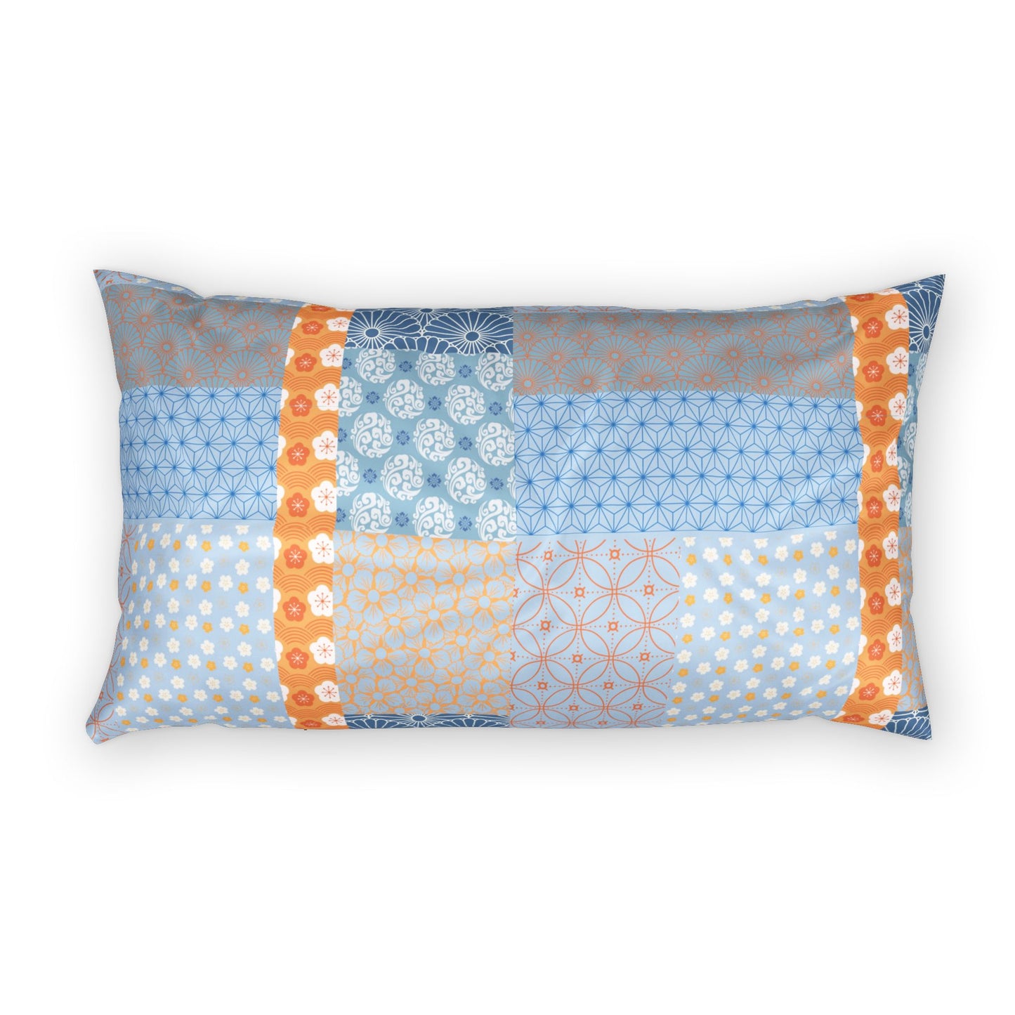 A rectangular lumbar pillow featuring a patchwork design of various Japanese-inspired patterns in shades of blue, orange, and gray, set against a plain white background.