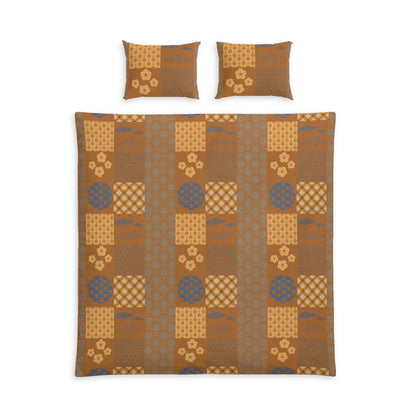 A bedding set featuring a patchwork quilt and two matching pillowcases with a Japanese-inspired pattern in shades of brown, beige, and muted blue-gray, shown on a plain white background.