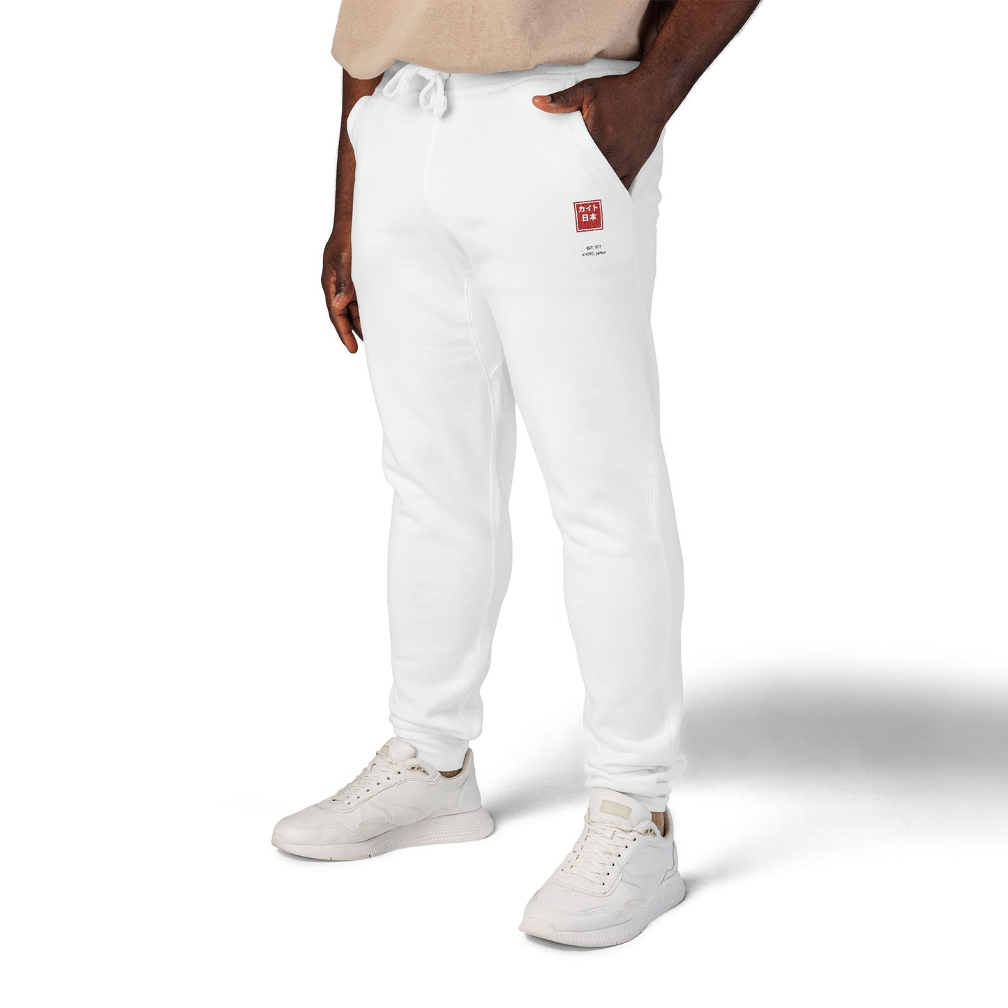 Person wearing white jogger pants and white sneakers on a white background
