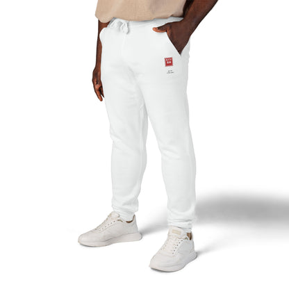 Person wearing white jogger pants and white sneakers on a white background