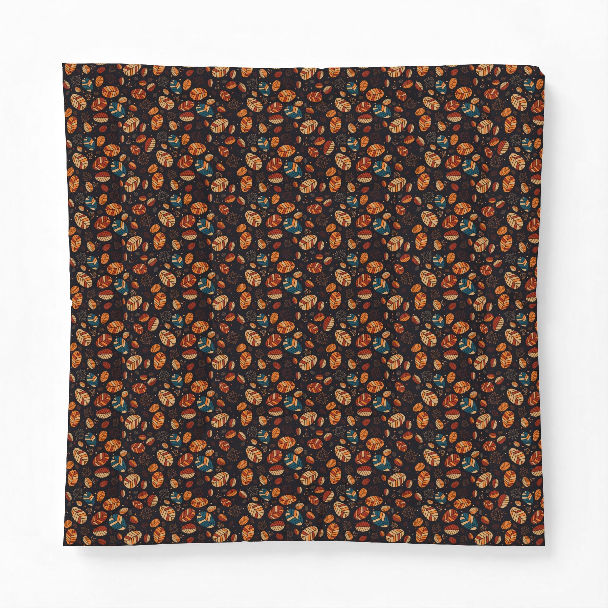 A square fabric item, likely a bandana or scarf, featuring an all-over dense pattern of small illustrated faces in orange, brown, and teal on a very dark background, displayed flat against a light gray backdrop.