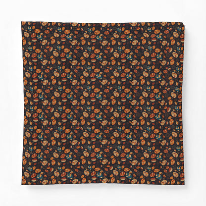 A square fabric item, likely a bandana or scarf, featuring an all-over dense pattern of small illustrated faces in orange, brown, and teal on a very dark background, displayed flat against a light gray backdrop.