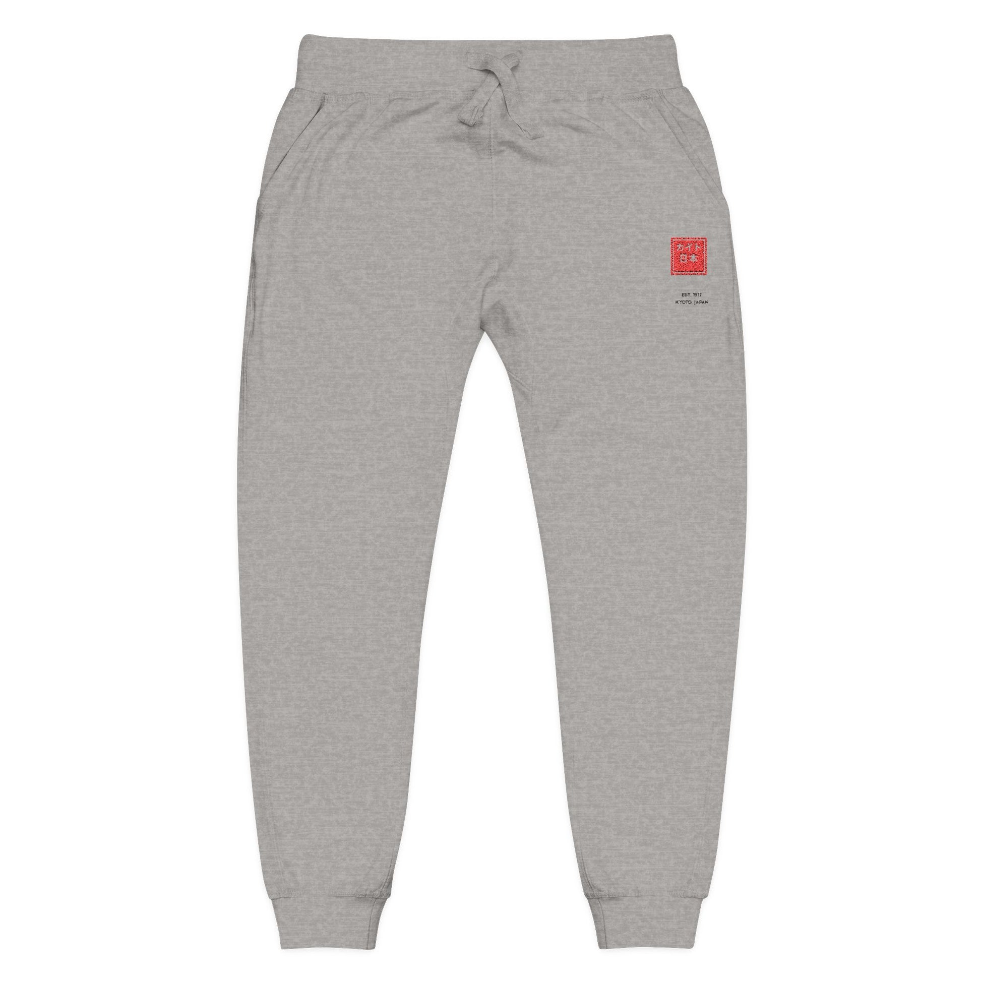 Gray sweatpants with a red logo patch on a white background
