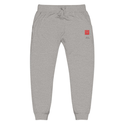 Gray sweatpants with a red logo patch on a white background