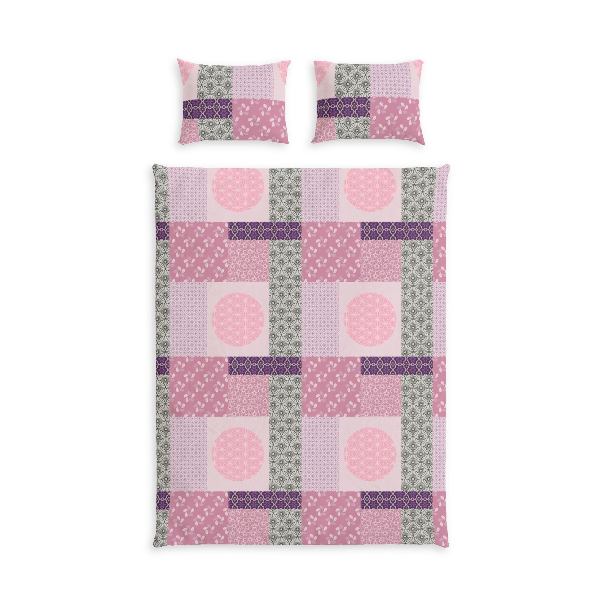 A bedding set featuring a patchwork quilt and two matching pillowcases in shades of pink, purple, and sage green, displayed on a clean white background.