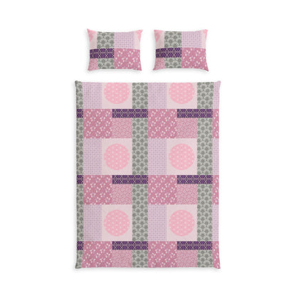 A bedding set featuring a patchwork quilt and two matching pillowcases in shades of pink, purple, and sage green, displayed on a clean white background.