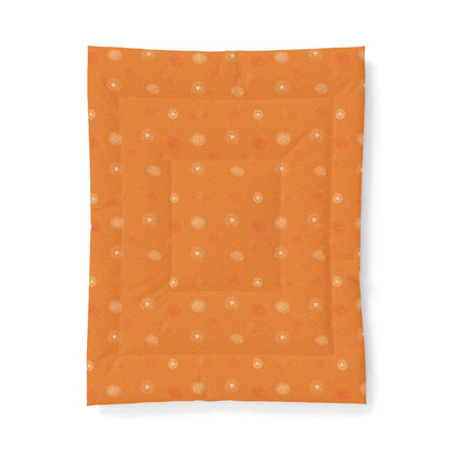 An orange quilted baby blanket with a subtle pattern of small white and orange dots, shown flat against a white background.