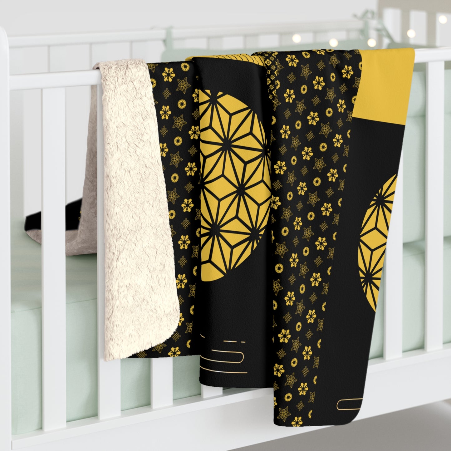 Black and yellow patterned blanket draped over a white crib