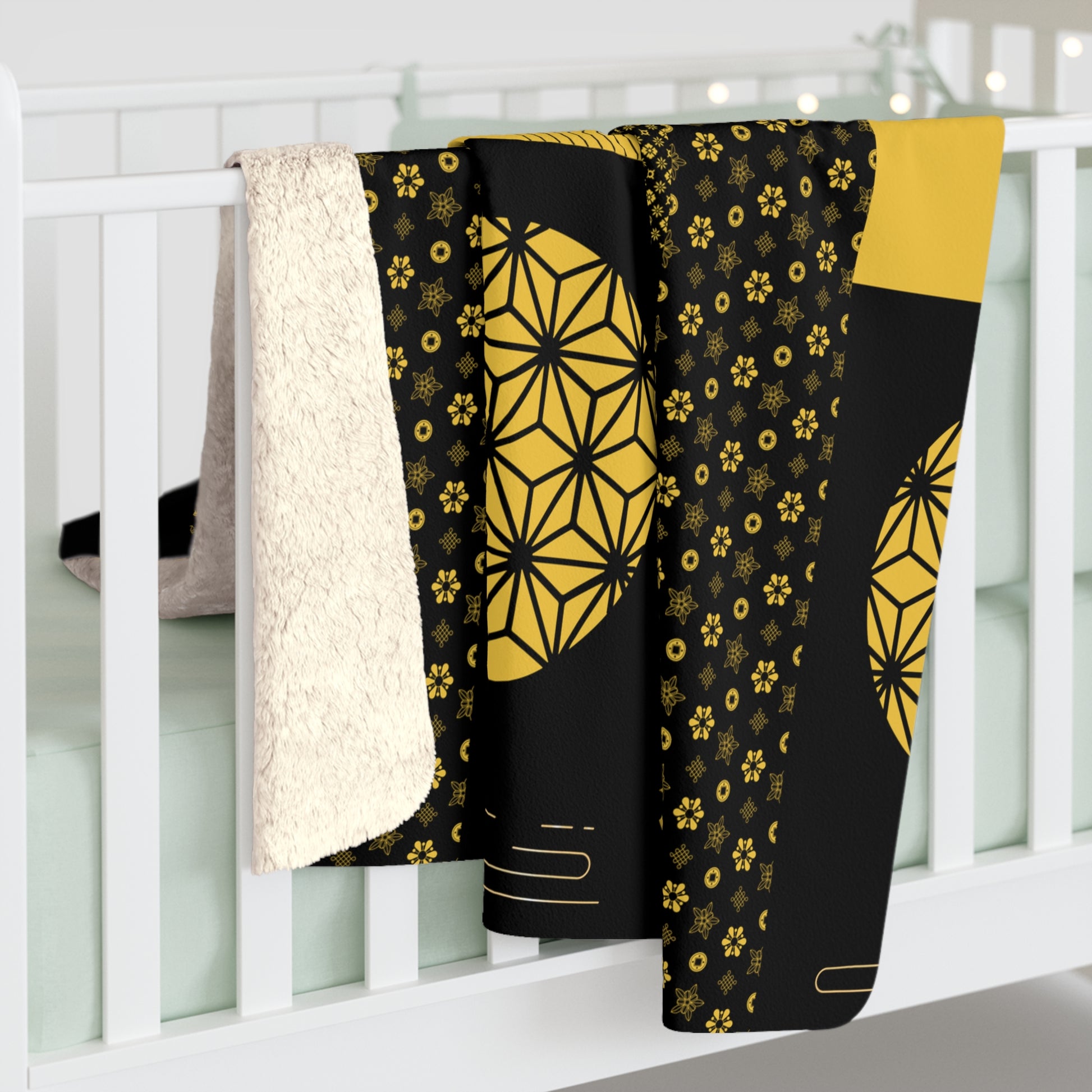 Black and yellow patterned blanket draped over a white crib