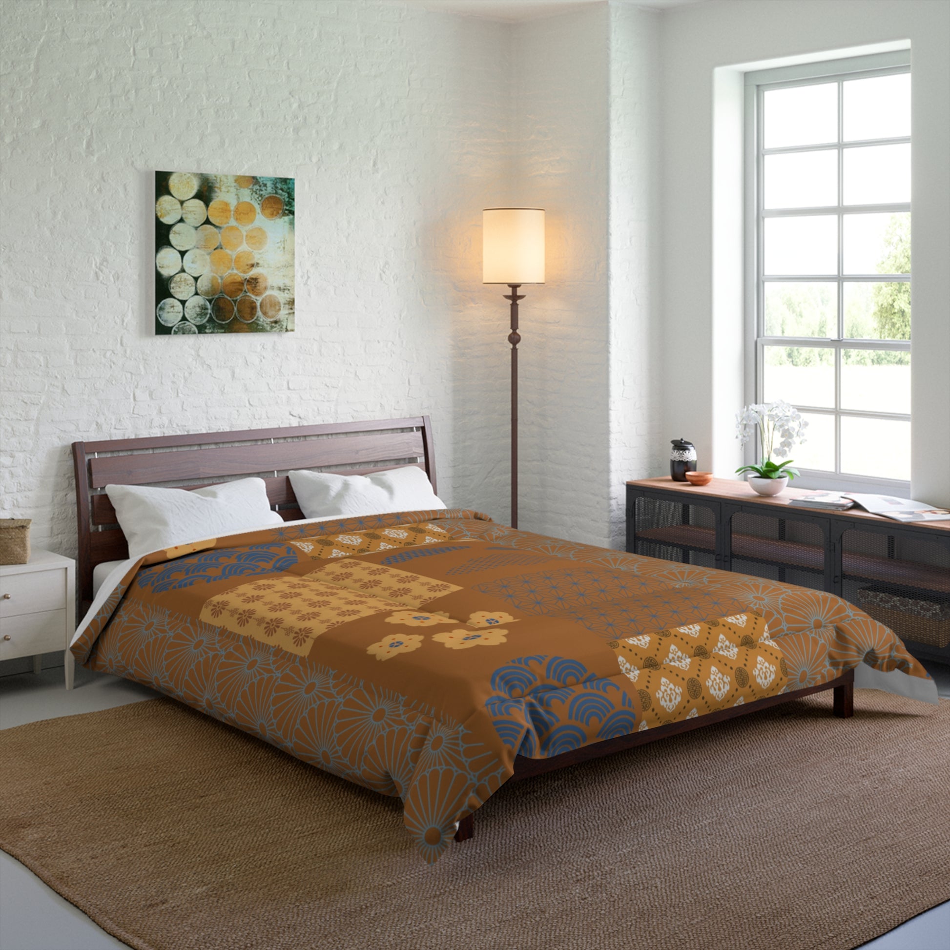 Bedroom with a bed covered in a patterned comforter, lamp, and artwork on the wall.