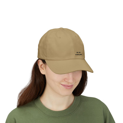 Person wearing a tan cap with a logo on a white background