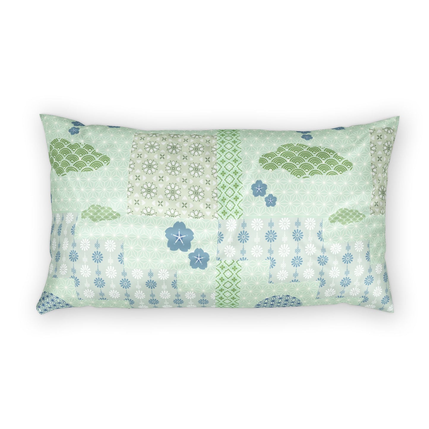 A rectangular lumbar pillow featuring a patchwork design of light green, sage, and blue patterns including clouds, flowers, and geometric motifs, set against a plain white background.