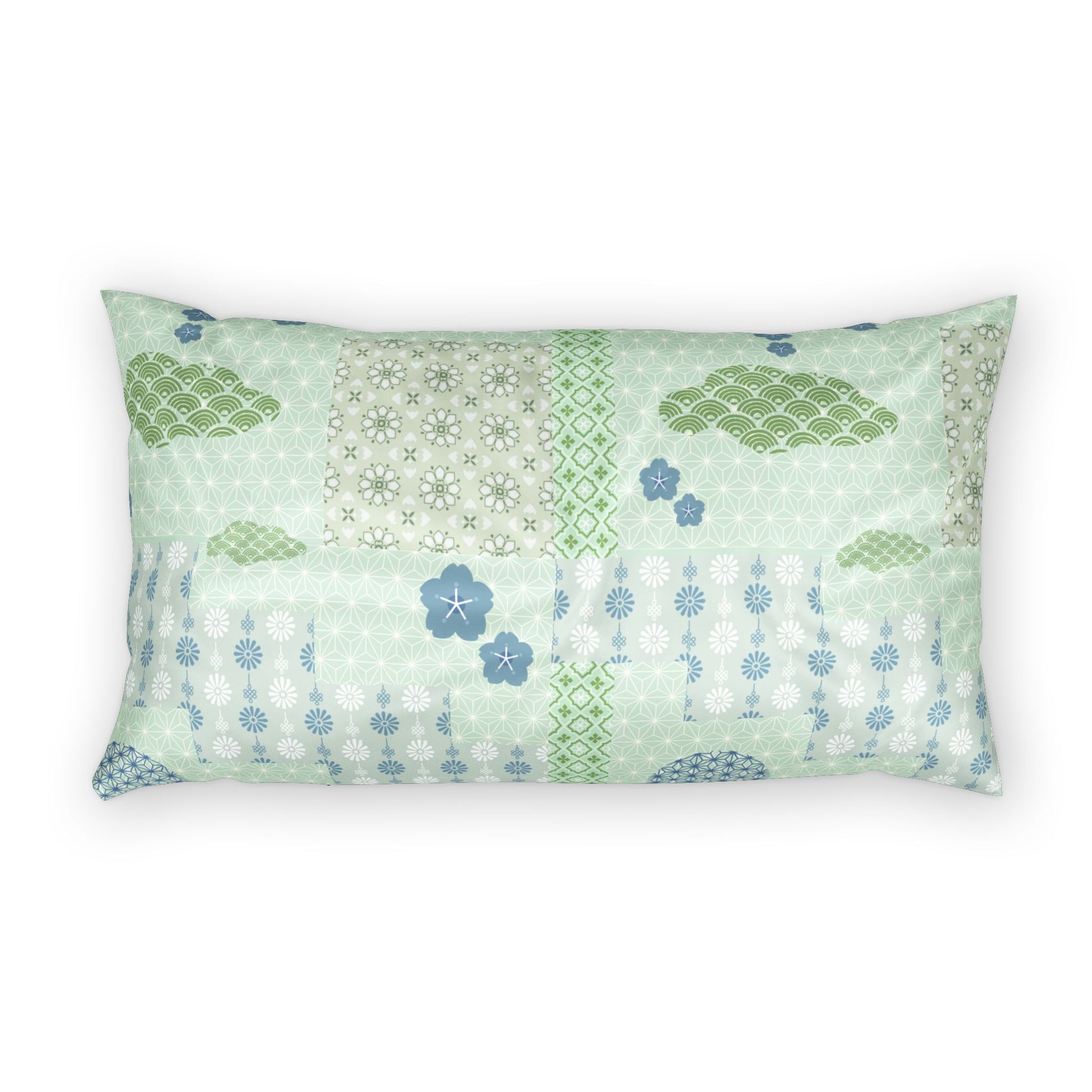 A rectangular lumbar pillow featuring a patchwork design of light green, sage, and blue patterns including clouds, flowers, and geometric motifs, set against a plain white background.