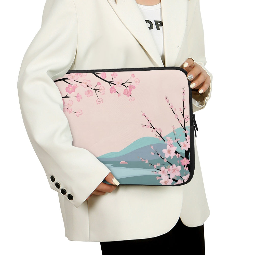 Person holding a laptop sleeve with cherry blossom design