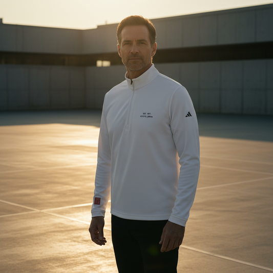 Man wearing a white Adidas jacket on an outdoor court