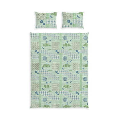 A bedding set featuring a duvet cover and two matching pillowcases with a patchwork-style geometric pattern in sage green, light blue, and beige on a white background.