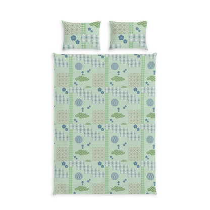 A bedding set featuring a duvet cover and two matching pillowcases with a light green and blue geometric pattern of trees, circles, and stripes, displayed on a solid white background.