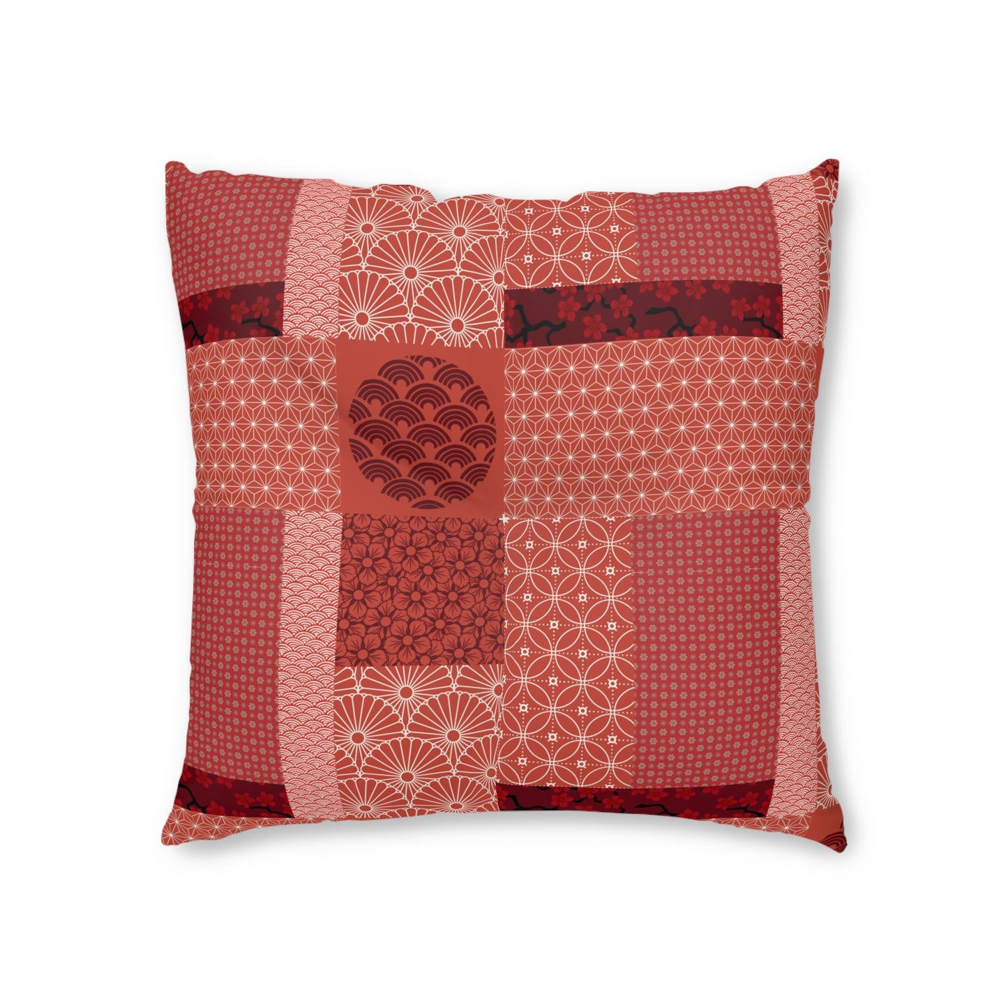 A square decorative throw pillow featuring a patchwork design of various Japanese-inspired patterns in shades of red, terracotta, and pink, set against a plain white background.