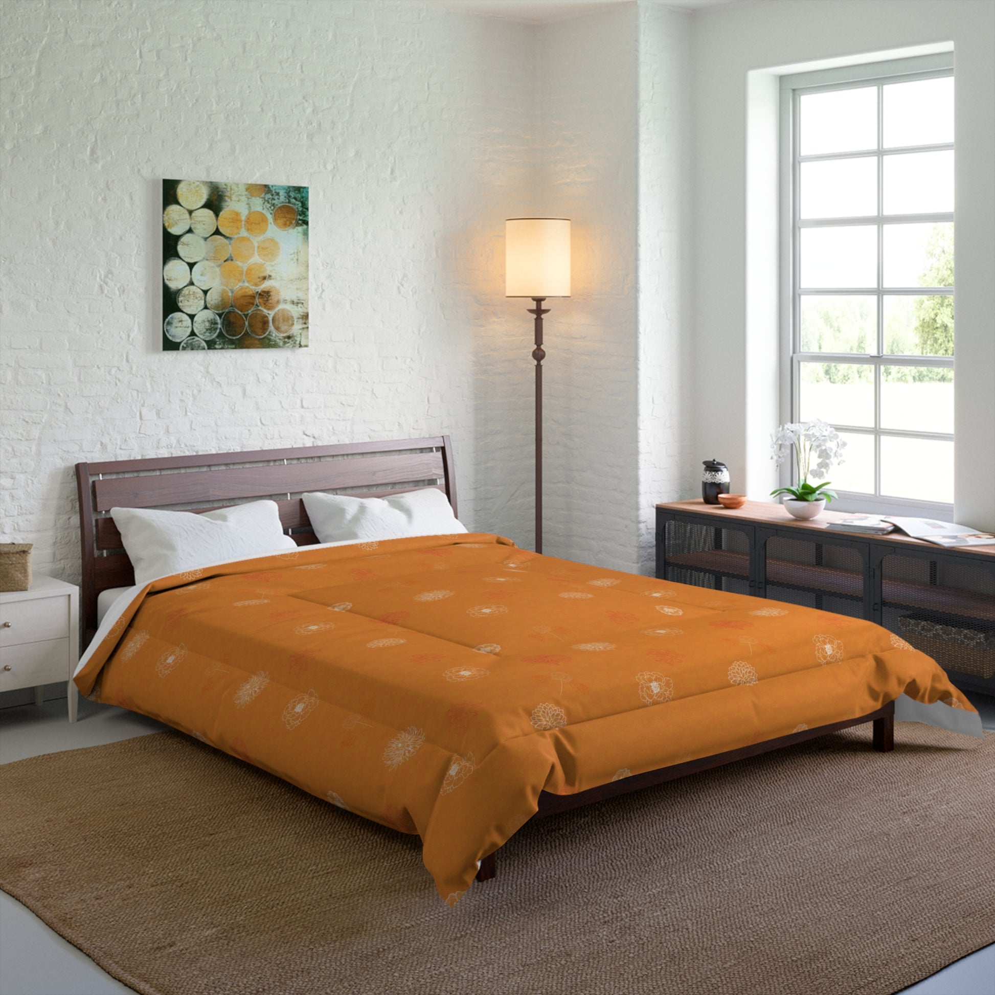 An orange patterned comforter set on a dark wood bed frame in a modern, bright bedroom with a white brick wall, floor lamp, and window.