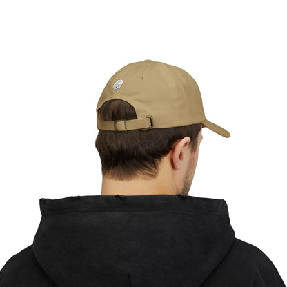 Person wearing a beige cap and black hoodie on a white background