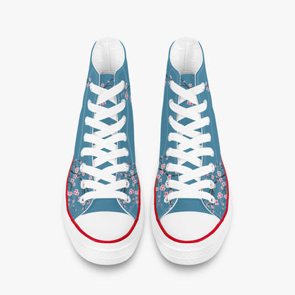 Pair of blue sneakers with floral patterns and white laces on a white background